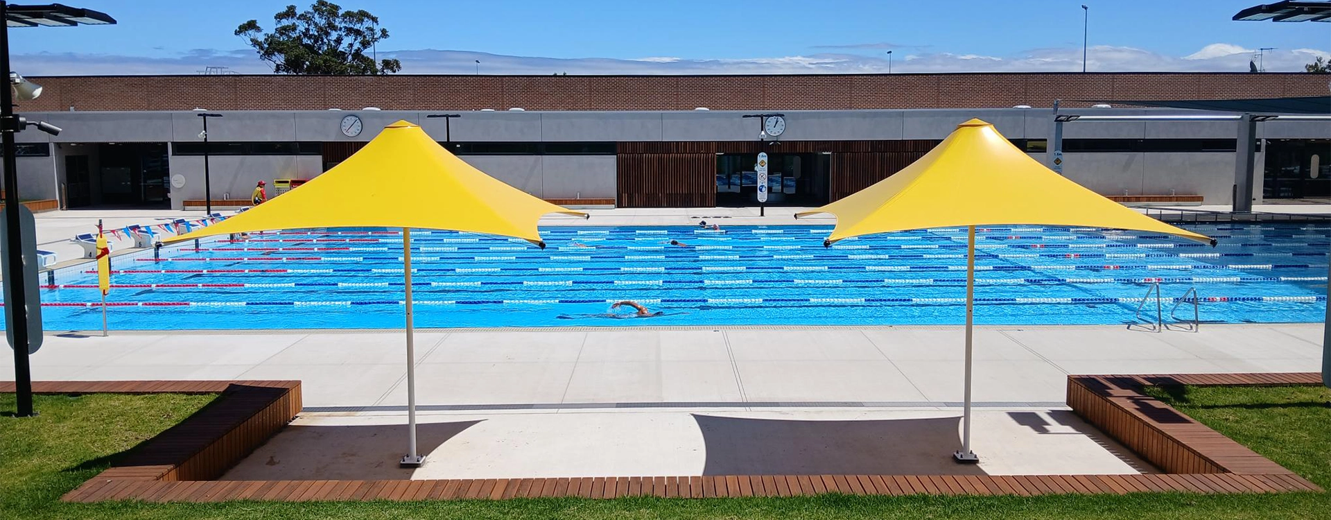 Some bright yellow outdoor umbrellas at Carnegie Memorial Swimming Pool